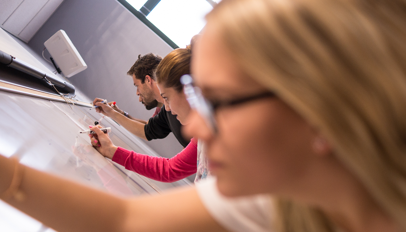 SBCC sociology majors in class and writing on the board.